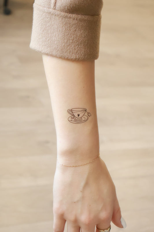 Person with a small tattoo on their wrist against a neutral background